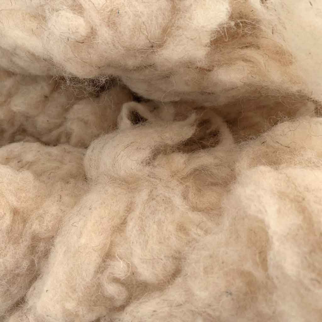 Close-up of natural wool stuffing fibers – breathable, chemical-free, ideal for sustainable filling and craft use.