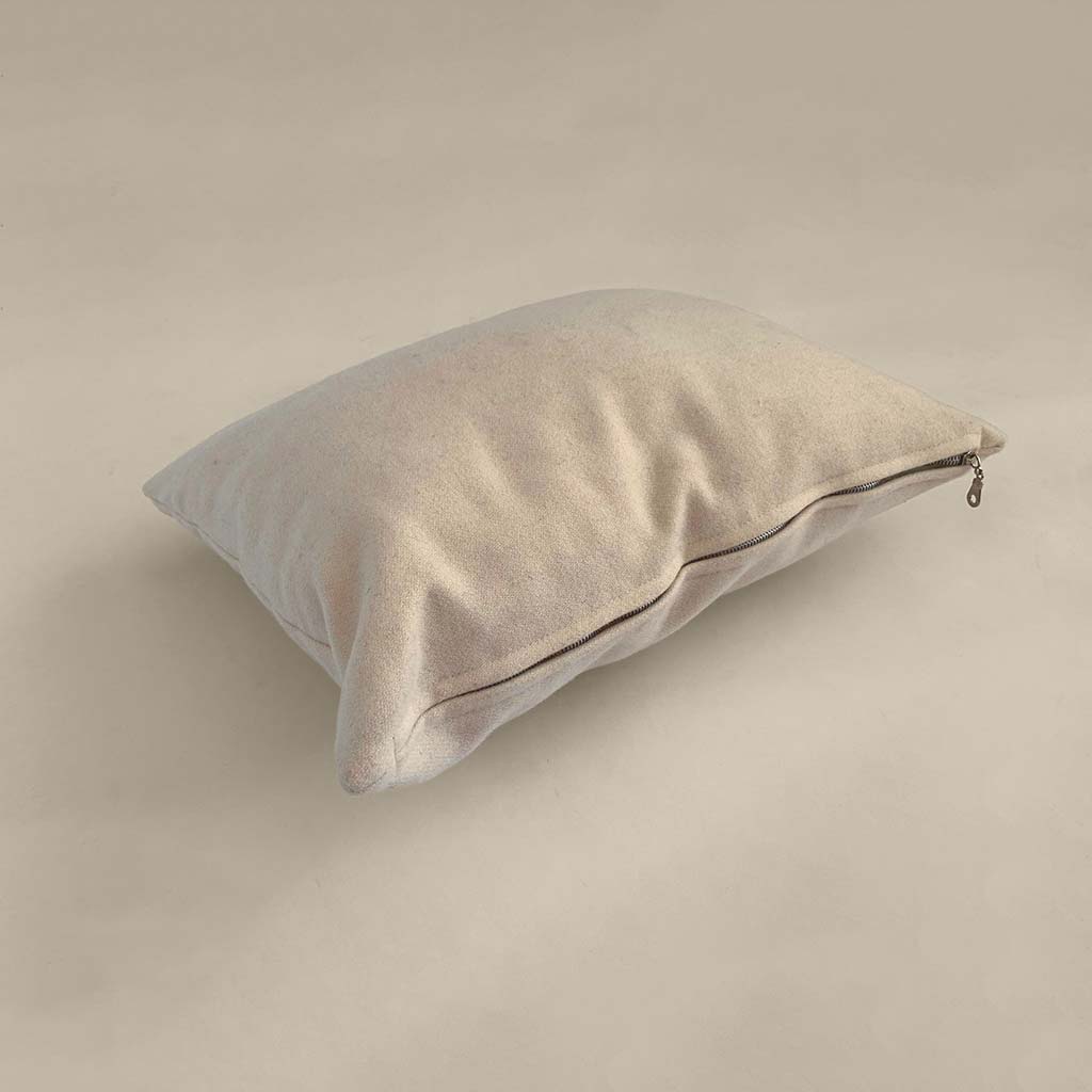 Natural wool pillow with soft fabric cover and zippered closure, offering breathable, adjustable comfort