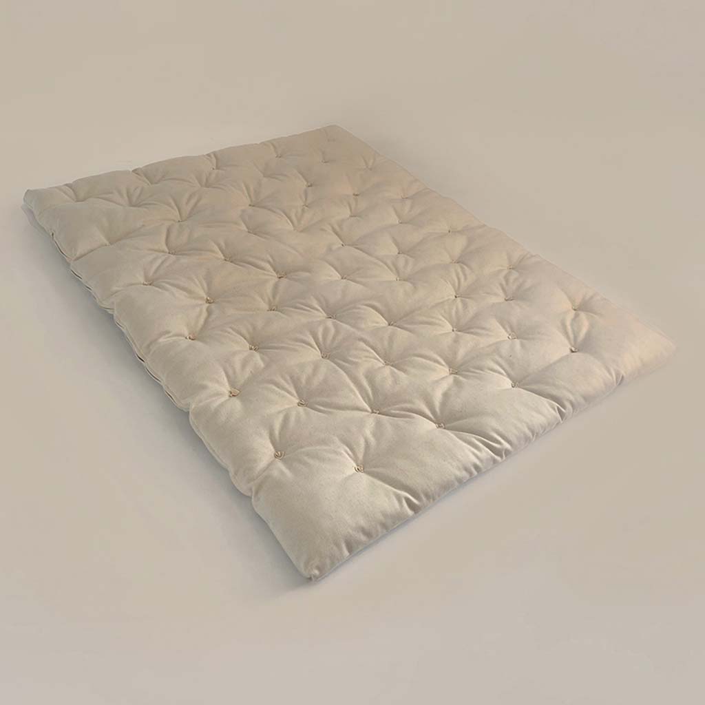 Top view of a handmade wool mattress topper with tufted surface and certified natural materials