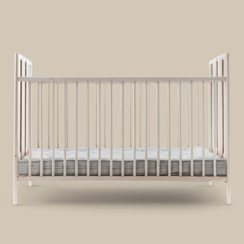 Wool crib mattress inside a natural wooden crib, designed for safe, breathable, and chemical-free sleep for babies