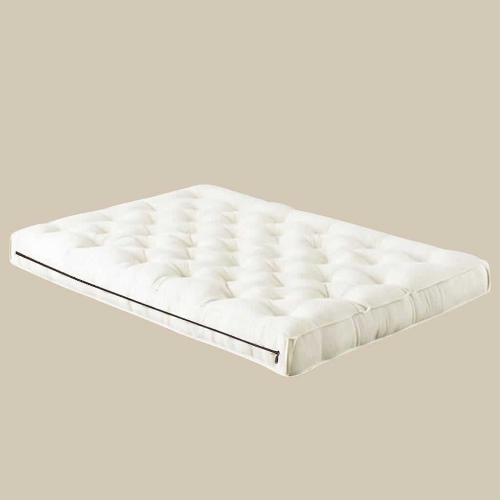 Wool crib mattress with hand-tufted surface and zippered edge, made from natural materials for breathable, chemical-free baby sleep
