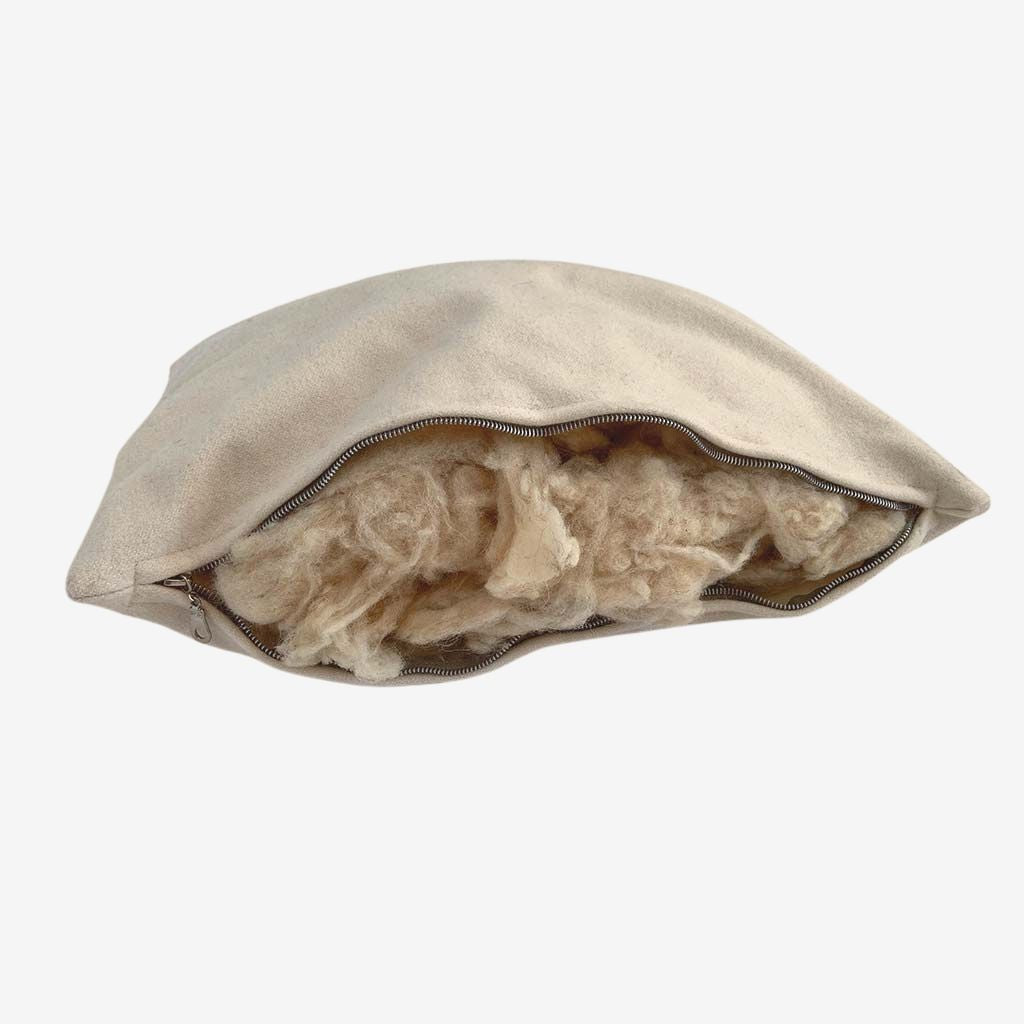 Natural wool pillow with zippered opening, showing breathable wool filling for adjustable, chemical-free comfort.